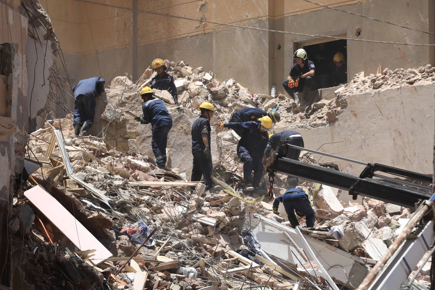 Mitglieder des ägyptischen Zivilschutzes bei den Überresten des eingestürzten 13-stöckigen Wohngebäudes in Alexandria.