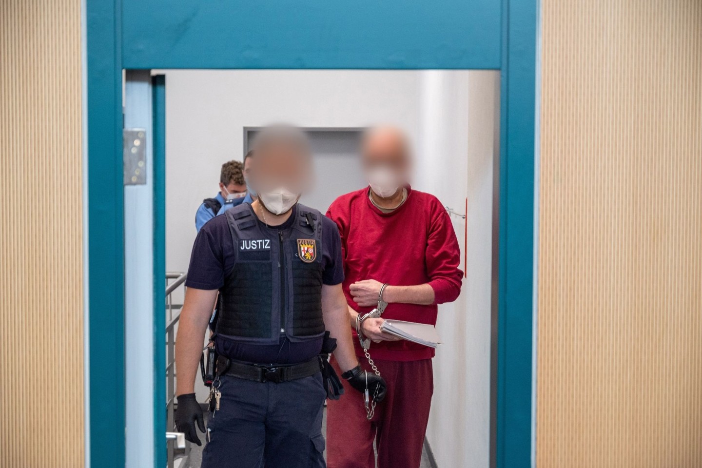 Ein Justizbediensteter begleitet den 52-jährigen Angeklagten (r) zum Prozess um die tödliche Amokfahrt in Trier in den Gerichtssaal des Landgerichts. Er war am 1. Dezember 2020 in einem Au...