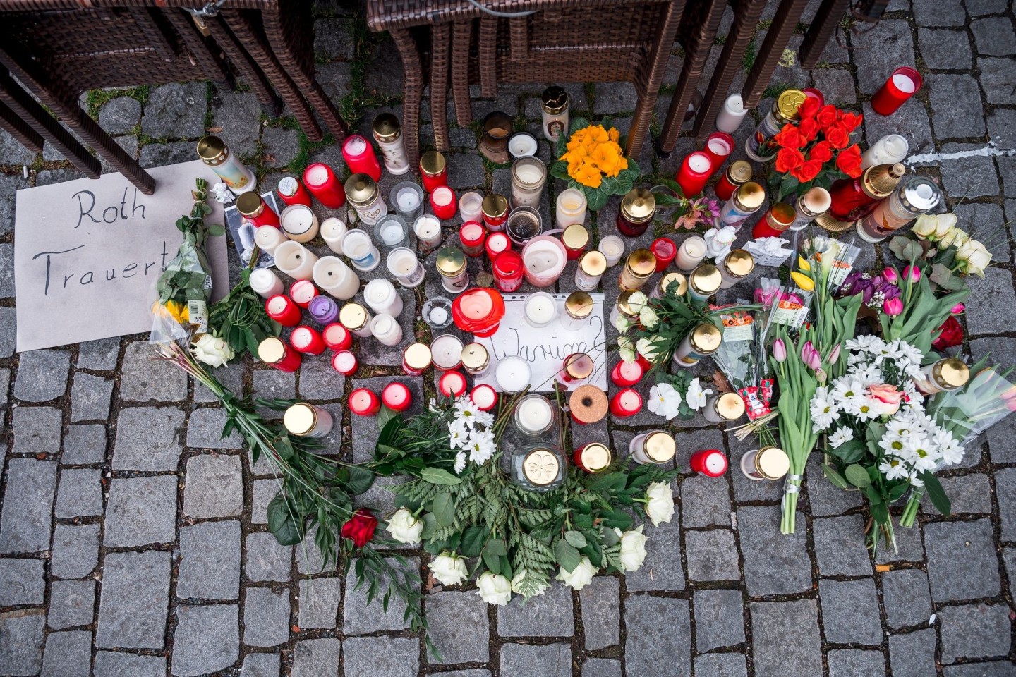 Auf dem Platz vor dem Blumengeschäft sind Blumen und Kerzen als Zeichen der Trauer niedergelegt.
