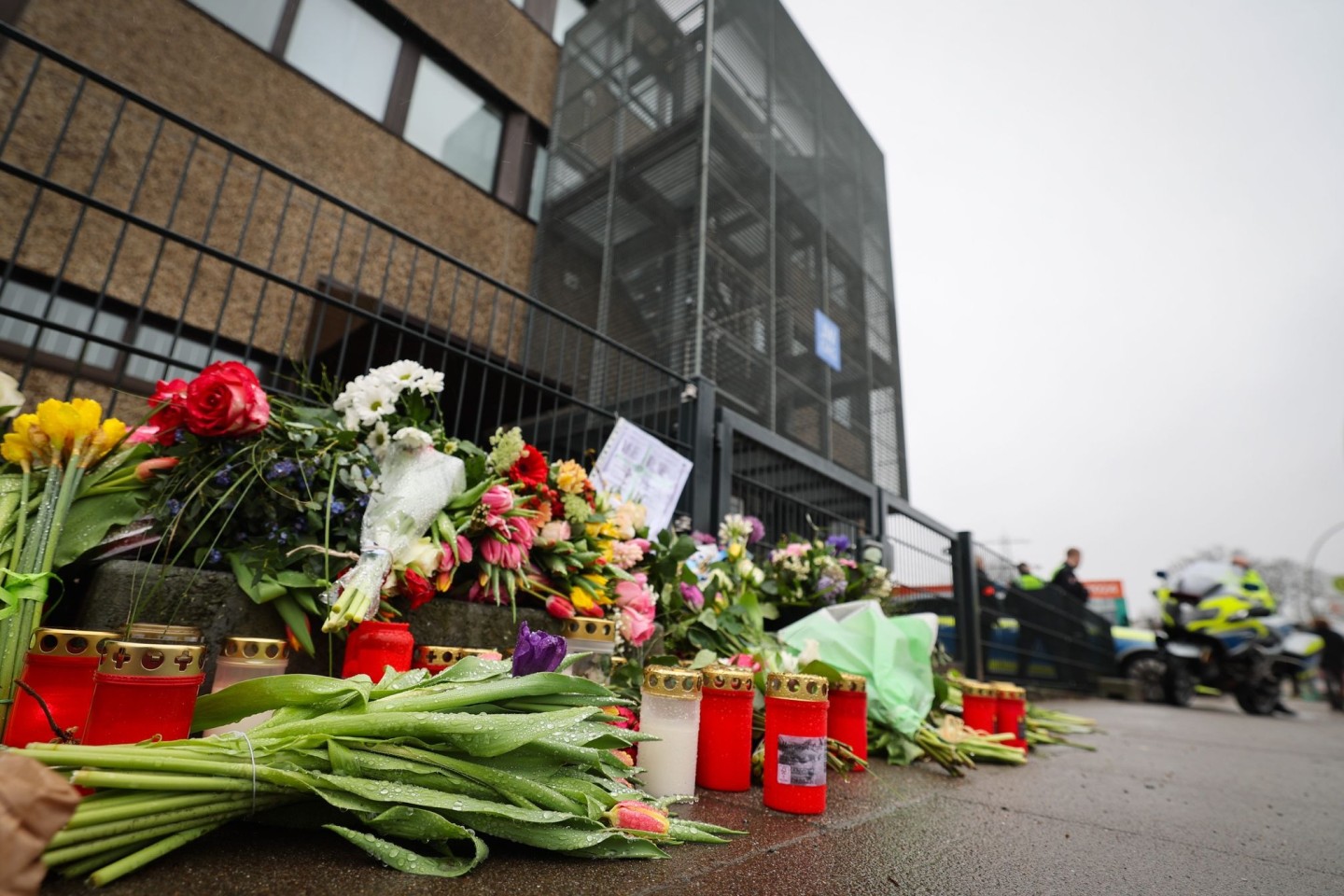Blumen und Kerzen erinnern vor dem Eingangsbereich des Gemeindehauses in Hamburg an die Opfer der Amoktat.
