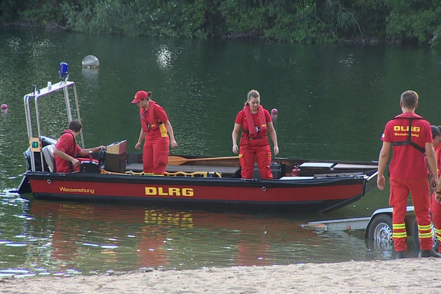 Mitarbeiterinnen und Mitarbeiter der DLRG suchen auf einem Badesee nach einem Jugendlichen in Nordrhein-Westfalen.