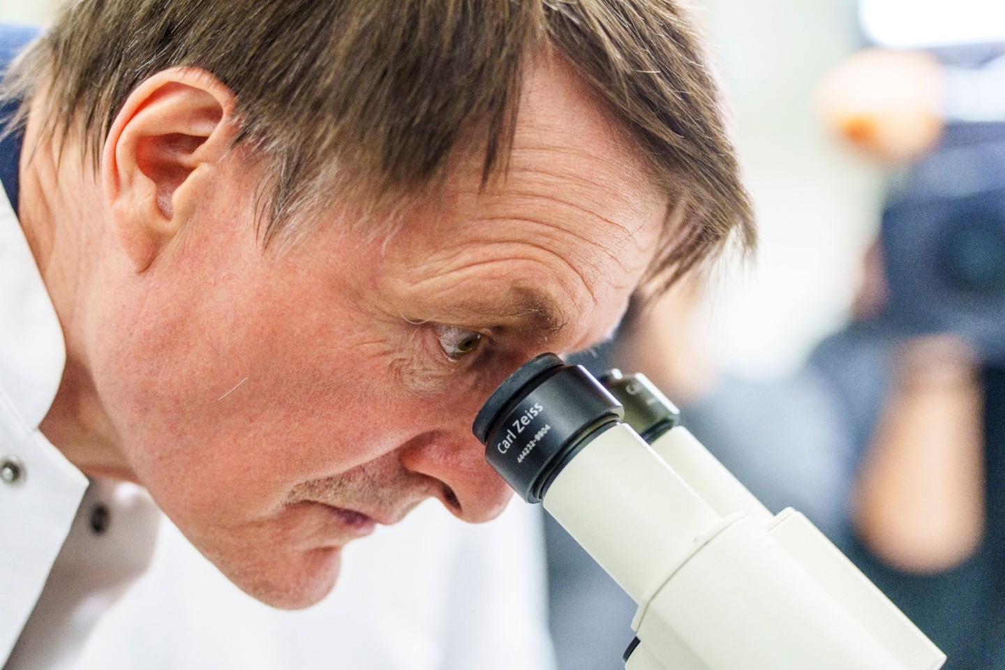 Karl Lauterbach (SPD), Bundesgesundheitsminister, betrachtet unter einem Mikroskop Krebszellen.