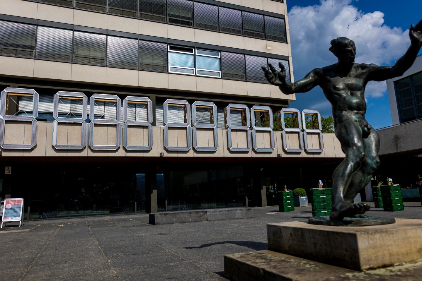 Eine «ClimateCrisisClock» hängt am Forumsgebäude der Technischen Universität (TU) Braunschweig hinter einer Dionysos-Skulptur.