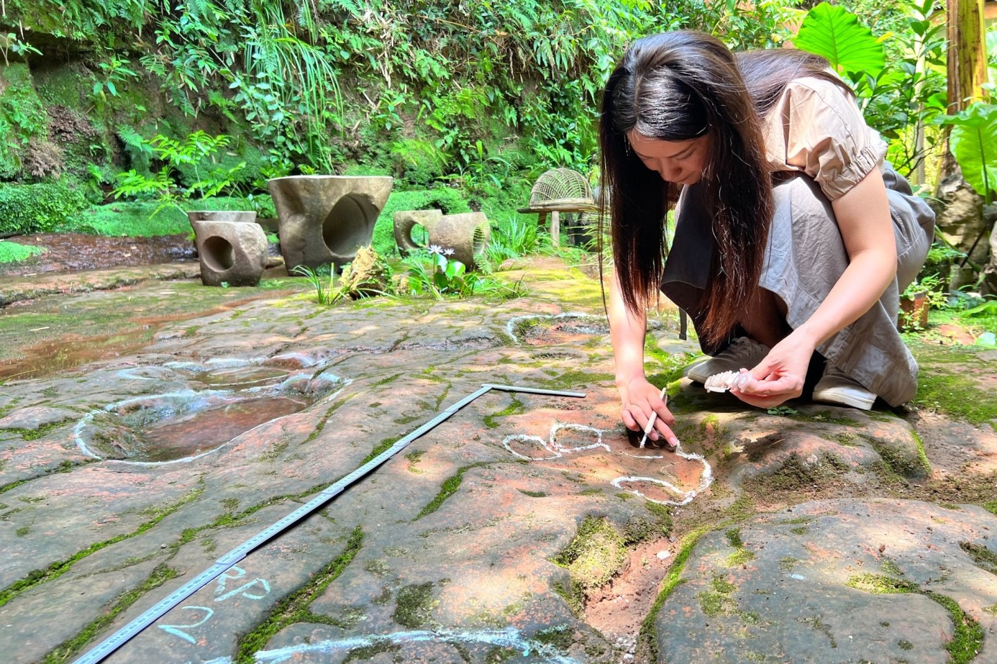 Eine Wissenschaftlerin im Forscherteam von Lida Xing untersucht die etwa 100 Millionen Jahre alte Dinosaurier-Fußabdrücke.
