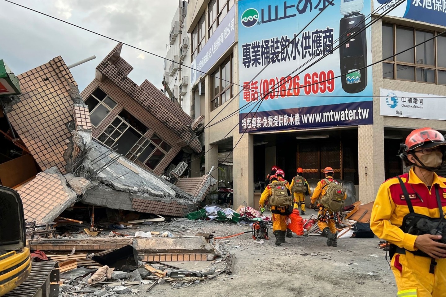 Feuerwehrleute bei der Suche nach Verschütteten in einem eingestürzten Wohnhaus nach dem Erdbeben im Osten Taiwans.