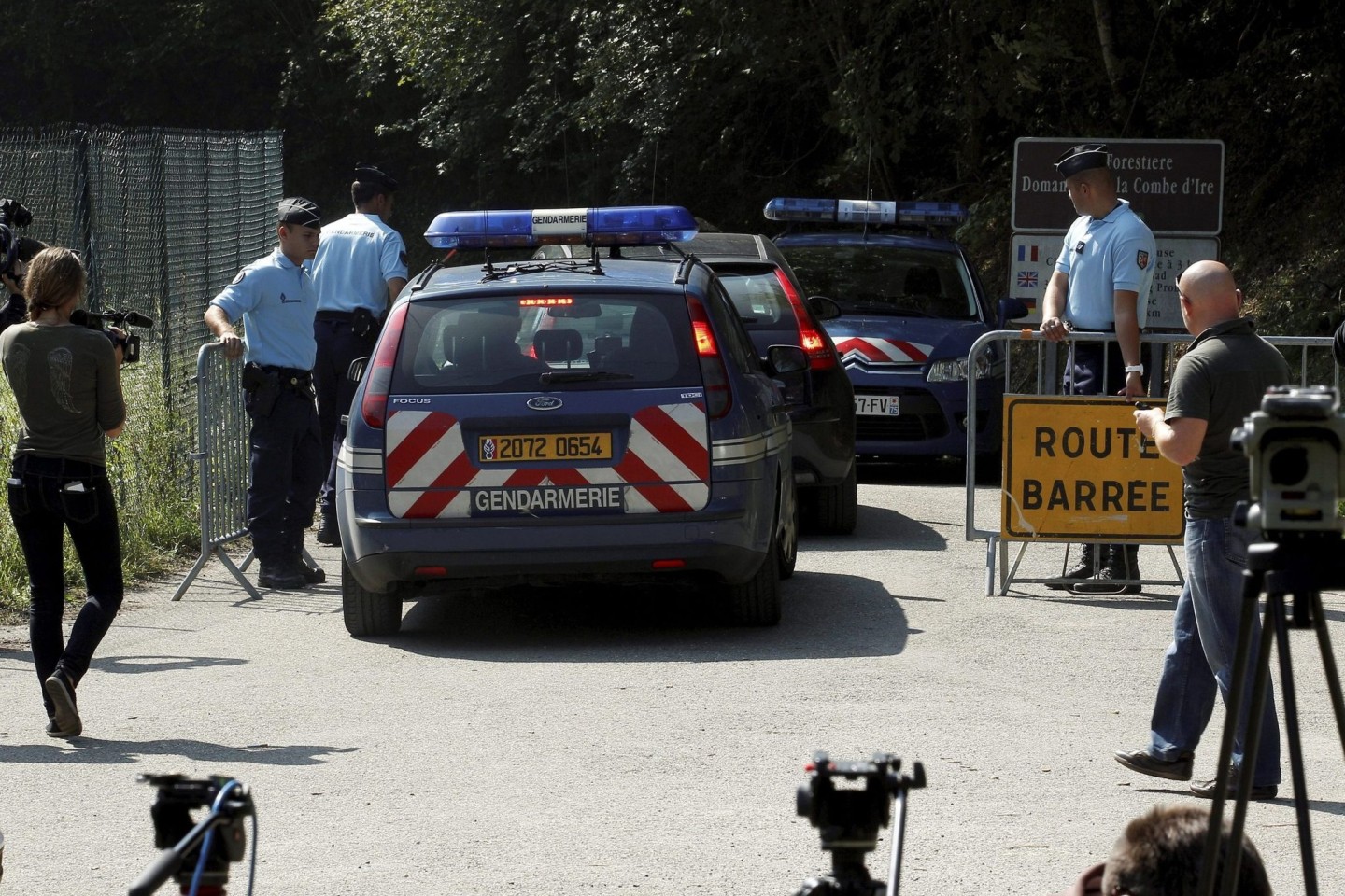ARCHIV) Die Polizei sperrt am 08.09.2012 die Straße zum Tatort des Mordes an einer britischen Familie bei Chevaline in den französischen Alpen ab.