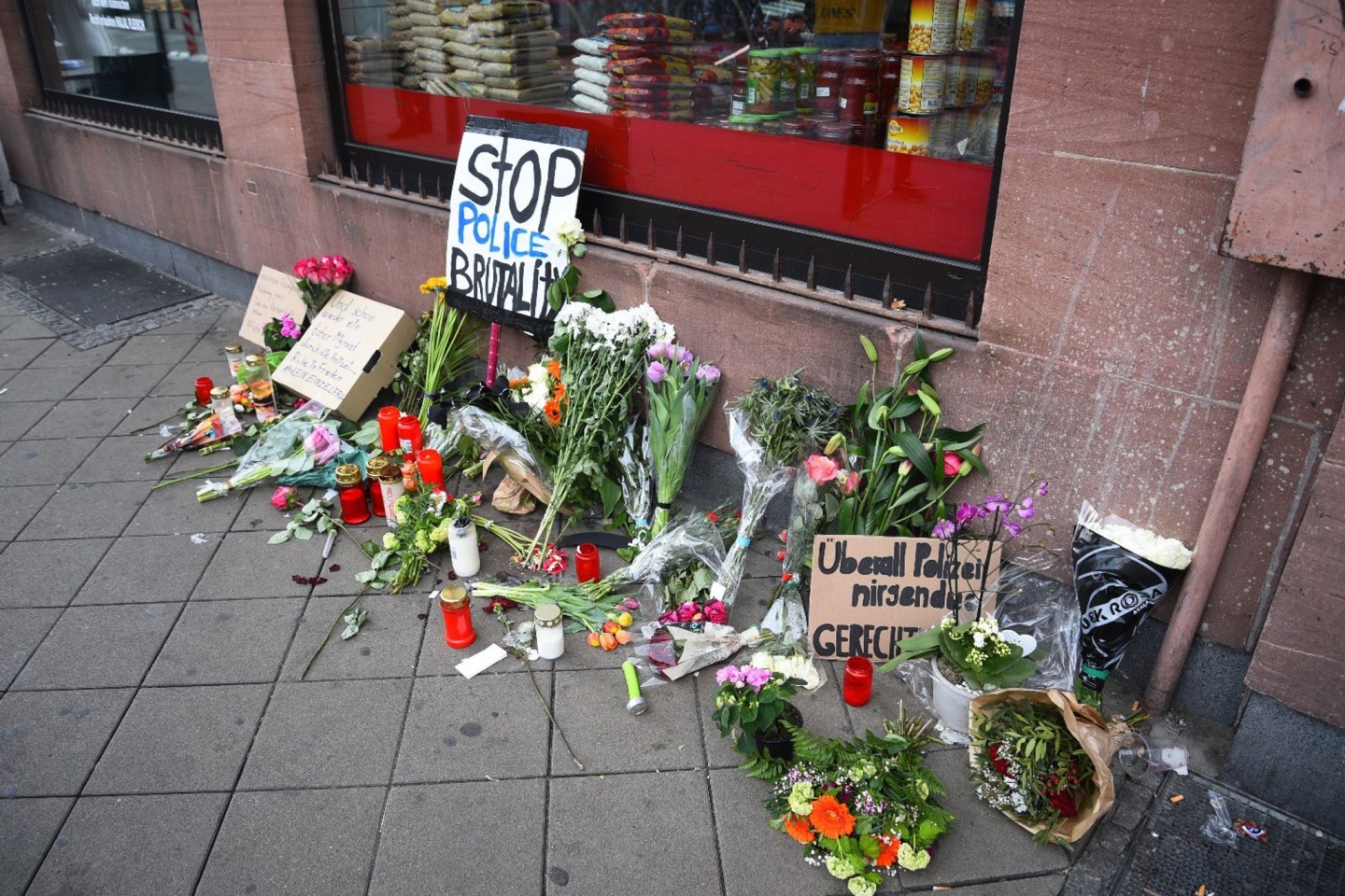 Blumen, Kerzen und Schilder liegen und stehen an dem Ort, an dem am 02.05.2022 ein Mann nach einer Polizeikontrolle gestorben ist. Der Tod des Mannes nach einem Polizeieinsatz in Mannheim l