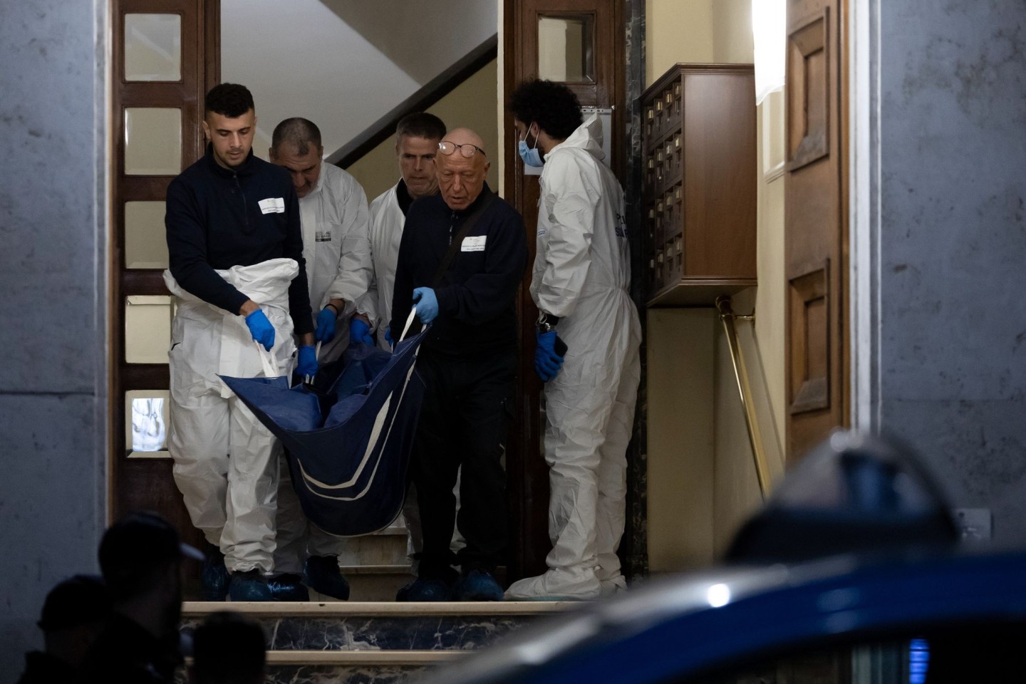 Einsatzkräfte der Polizei tragen einen Leichnam aus dem Haus in Rom.