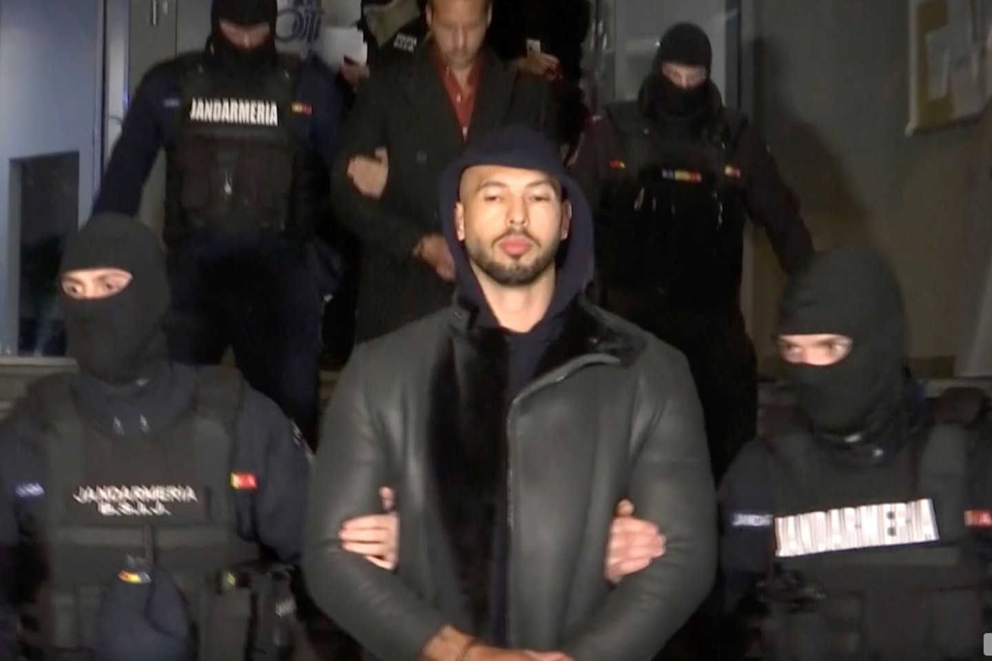 Dieses Videostandbild des Fernsehsenders Observator Antena 1 zeigt Andrew Tate (M) bei seiner Festnahme durch die rumänische Polizei.