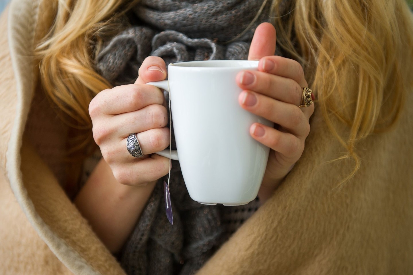 Eine Frau wärmt sich in Hannover, in eine Decke gehüllt, an einer Tasse Tee. Ab wann jemand friert, hängt von vielen Faktoren ab.