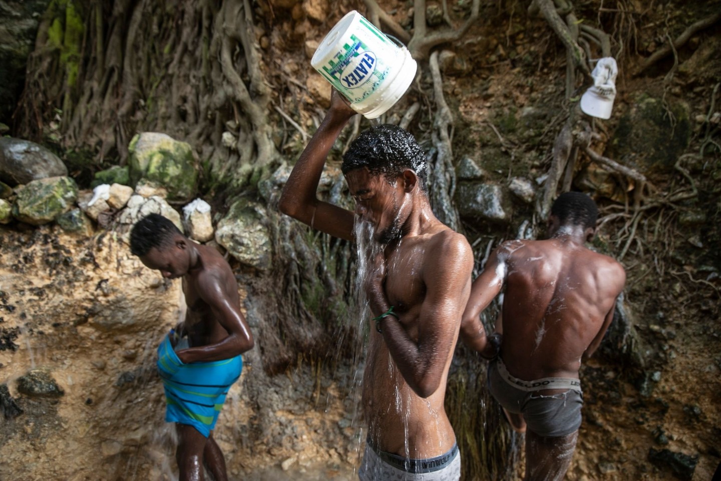 Menschen waschen sich in einer Schlucht in Port-Au-Prince.