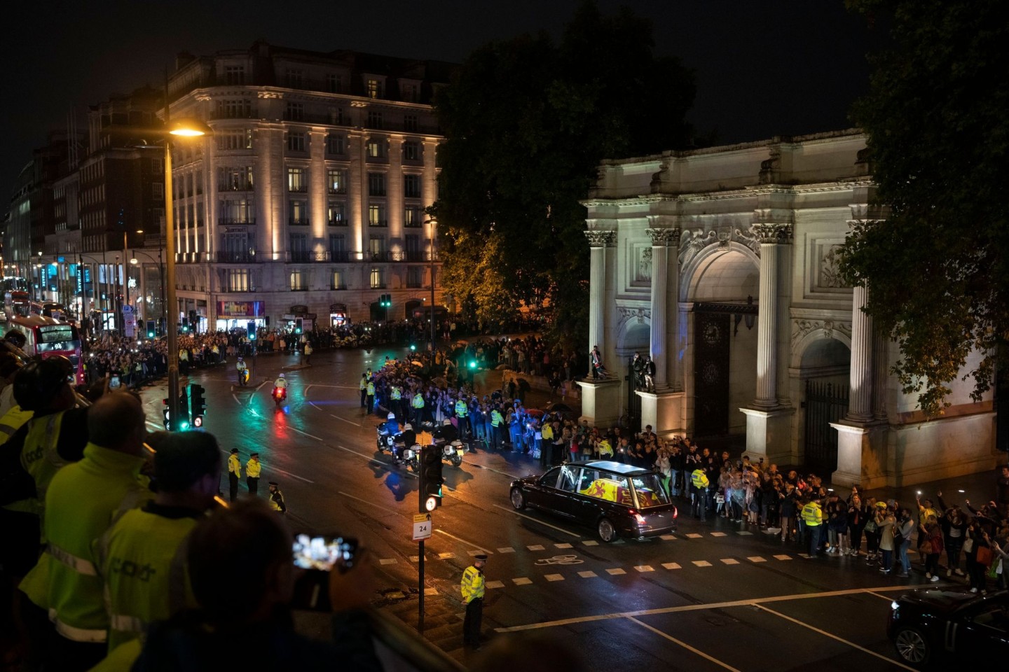 Menschen versammeln sich in der Nähe des Marble Arch, als der Leichenwagen mit dem Sarg von Königin Elizabeth II. zum Buckingham Palace fährt.