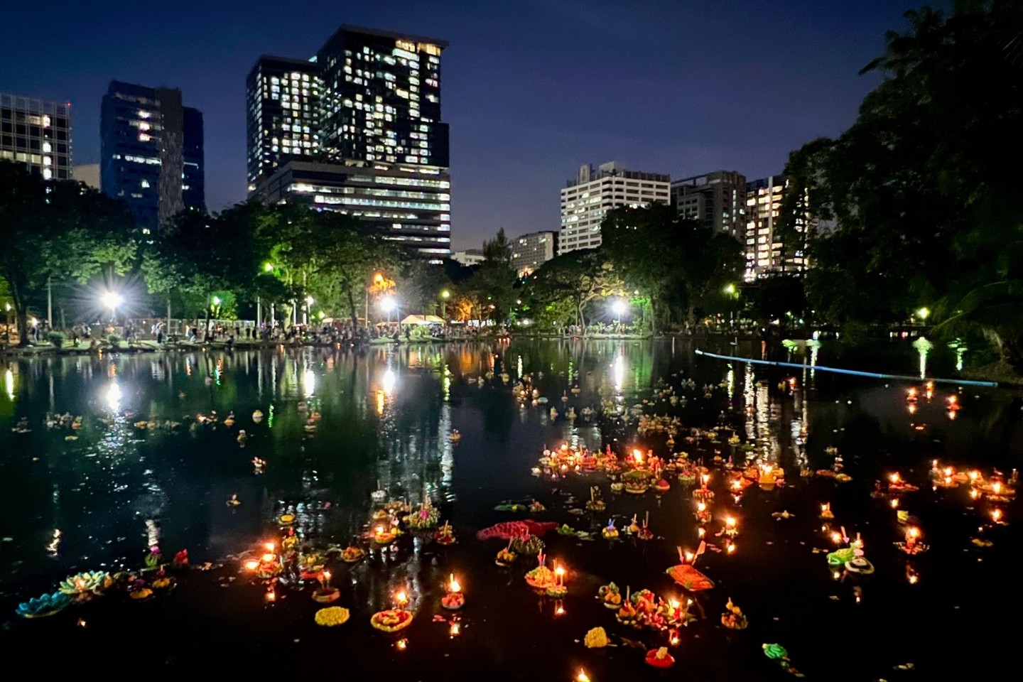 Krathongs schwimmen in einem See im Lumphini Park, einem der größten Parks Bangkoks.