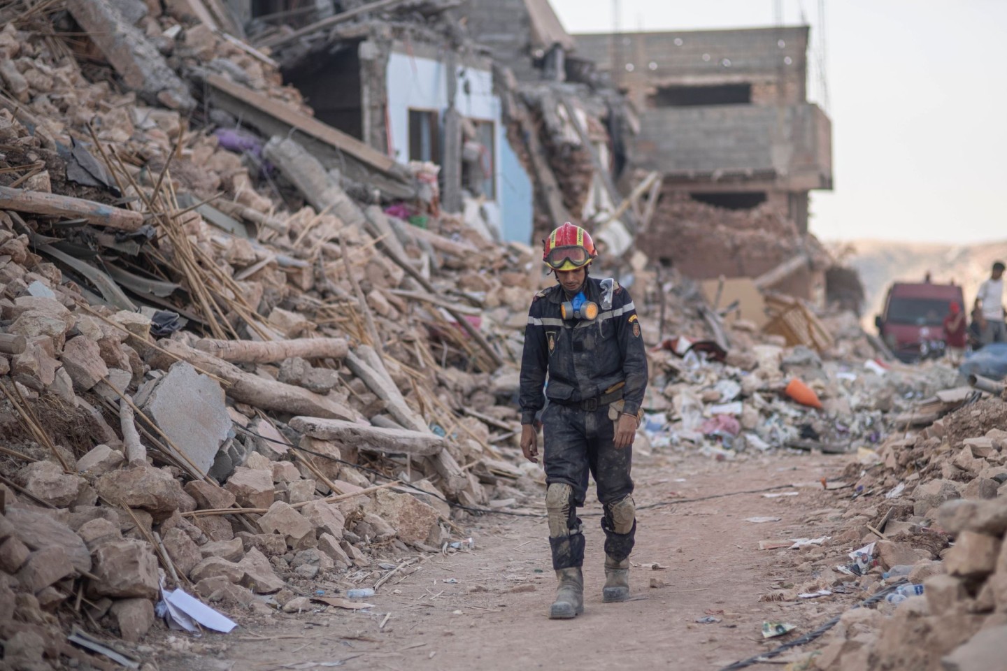 Ein Helfer geht in der Stadt Imi N'tala außerhalb von Marrakesch durch Trümmer.