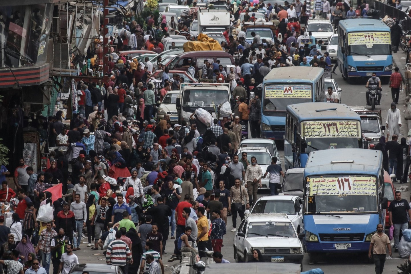 Menschen und Fahrzeuge drängen sich auf dem beliebten Straßenmarkt von Al Ataba in Kairo.