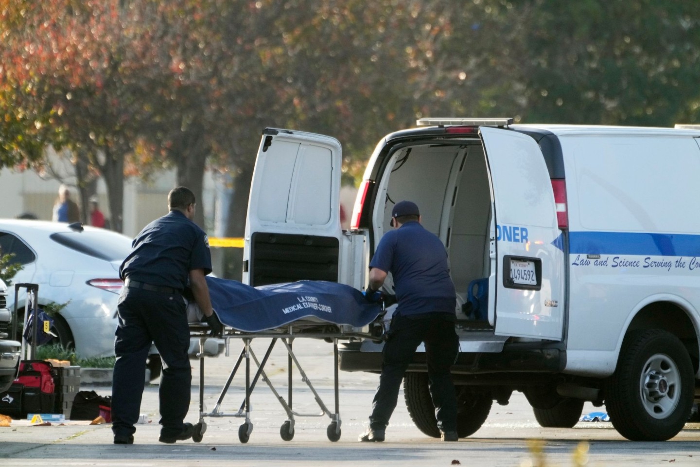 Die Leiche des mutmaßlichen Todesschützen wird vom Gerichtsmediziner des Bezirks Los Angeles aus einem Lieferwagen geholt.