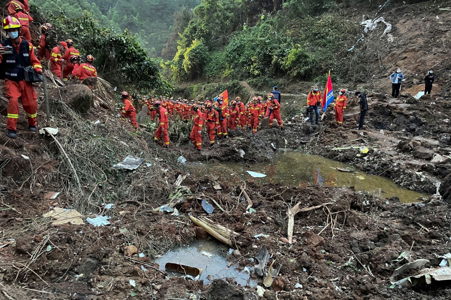 Auf diesem von der Nachrichtenagentur Xinhua veröffentlichten Foto führen Rettungskräfte Suchmaßnahmen an der Absturzstelle der Boeing 737-800 durch.