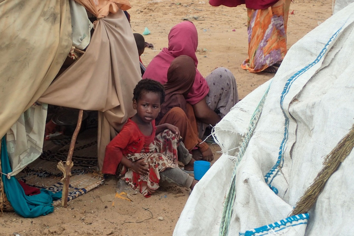 Von der Dürre betroffene Menschen sitzen vor einer Hütte im Lager für Binnenflüchtlinge Al-Hidaya am Rande von Mogadischu.
