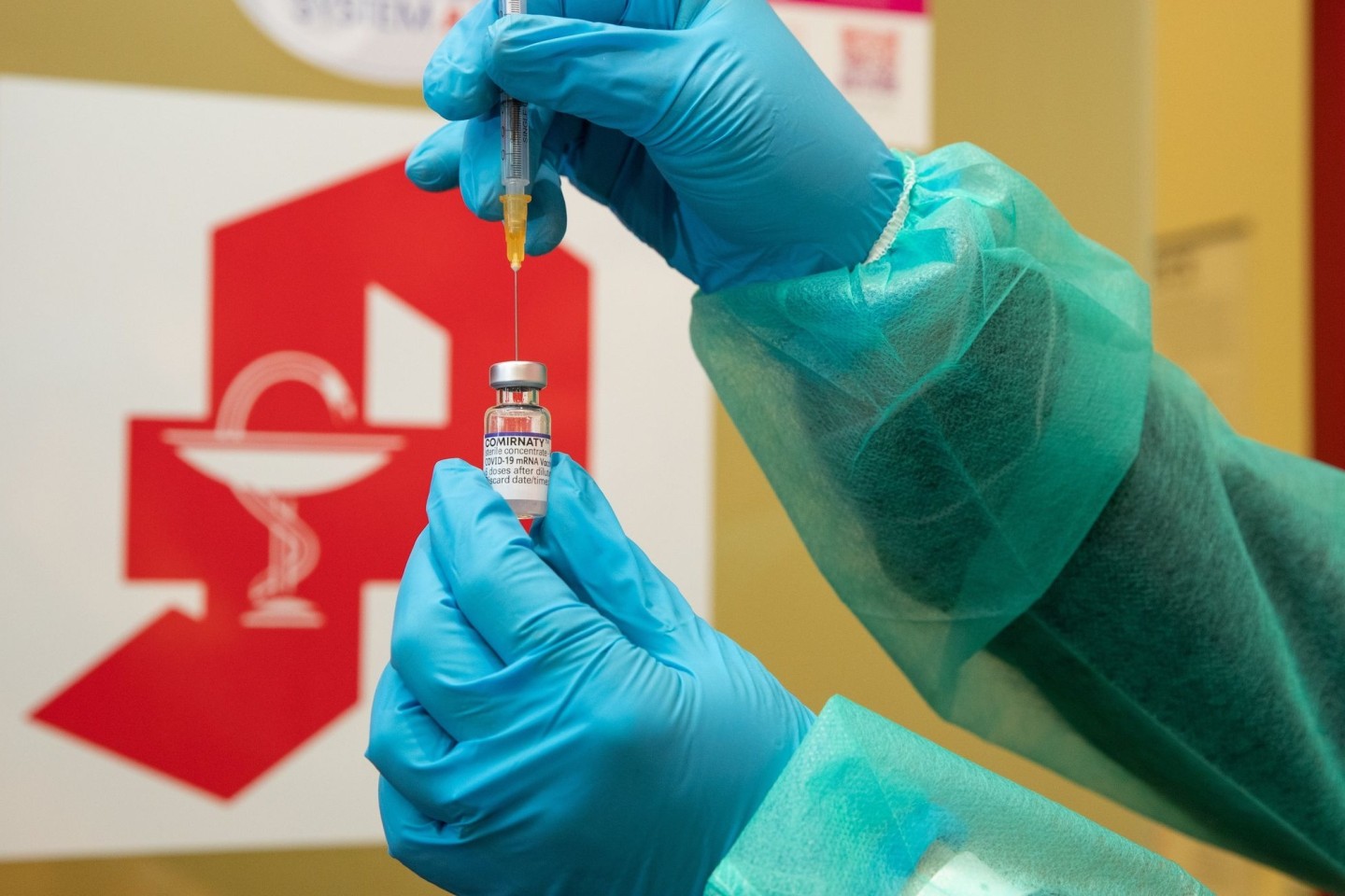 Eine Apothekerin zieht den Impfstoff Comirnaty vom Hersteller Biontech / Pfizer mit einer Spritze auf.