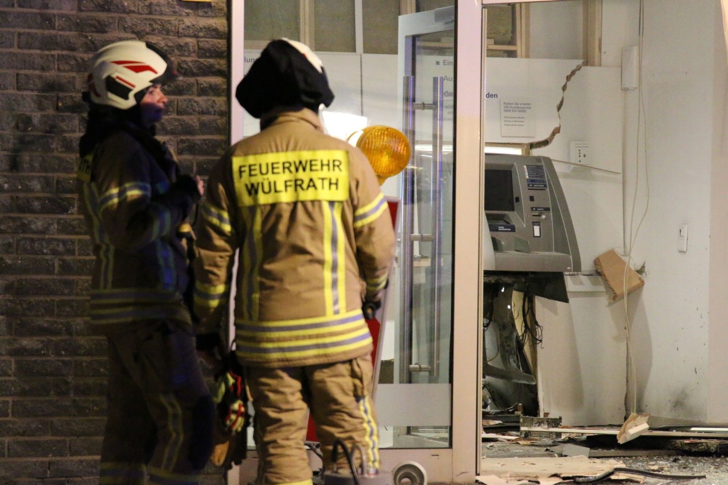 Feuerwehrleute stehen vor einem gesprengten Geldautomaten in Nordrhein-Westfalen.