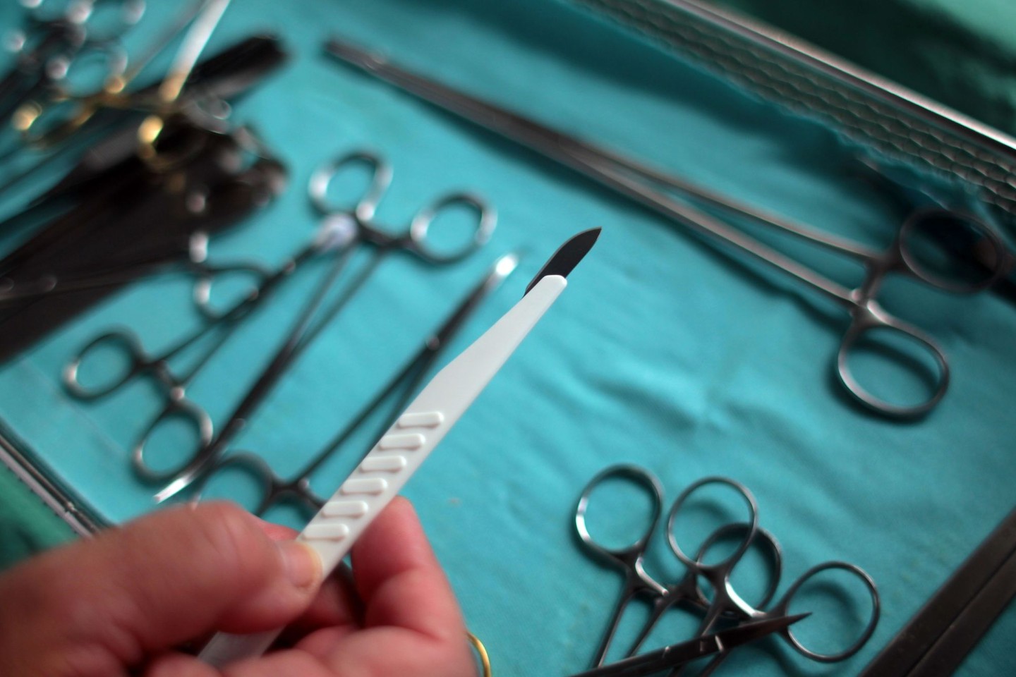 Der Chirurg hält im OP ein Skalpell in der Hand. (Archivbild)