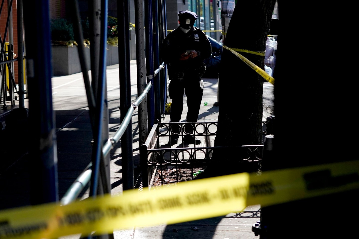 Ein Polizeibeamter steht in der Nähe des Tatorts, an dem eine junge Frau bei einer Schießerei in einem Wohnhaus in Brooklyn getötet wurde.