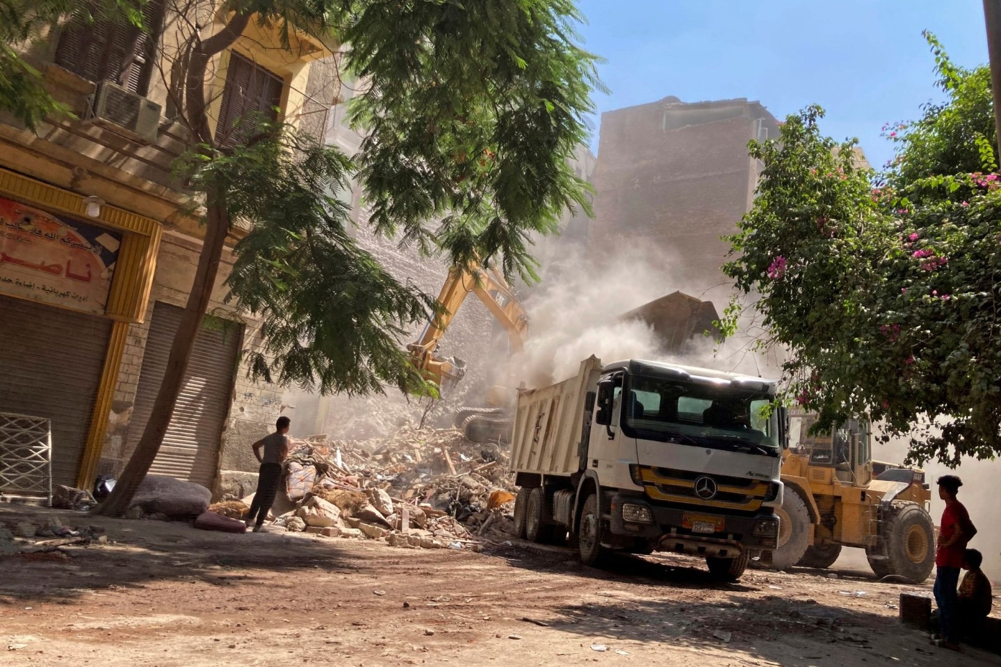 Anwohner und Rettungskräfte durchsuchen die Trümmer des eingestürzten Gebäudes in Kairo.