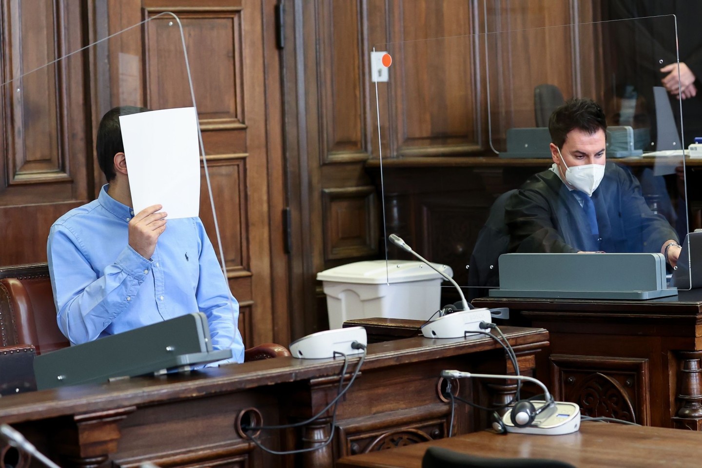 Der Angeklagte (l) sitzt neben seinem Anwalt Haydar Güler im Gerichtssaal im Strafjustizgebäude.