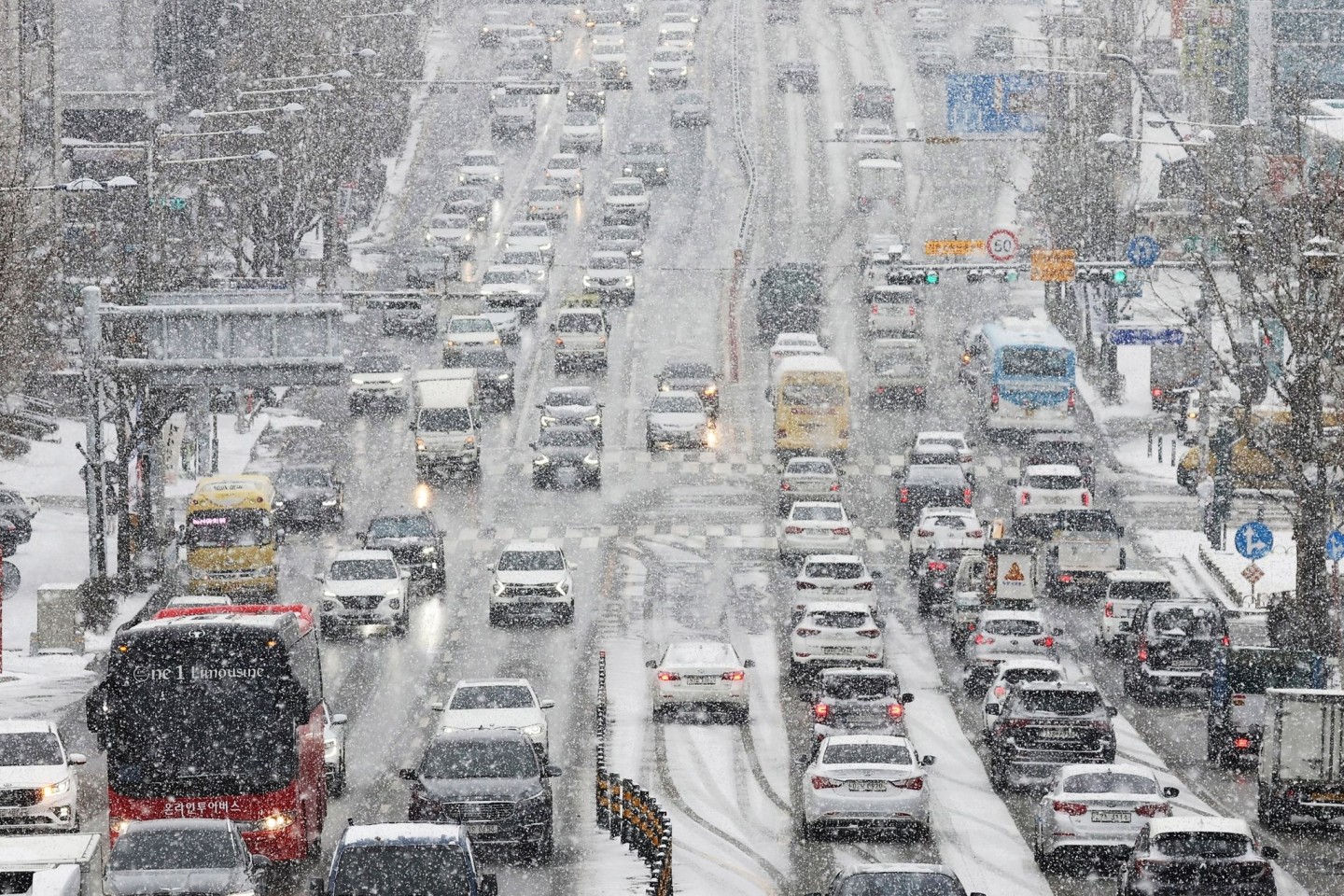 Dei starkem Schneefall drängen sich Fahrzeuge dicht an dicht auf einer Straße im südkoreanischen Suwon.