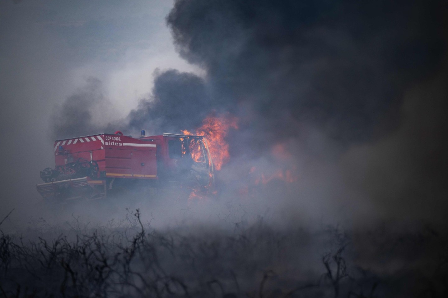 Feuerwehrfahrzeuge, die während eines Waldbrandes auf dem Mont d'Arrees außerhalb von Brasparts brennen.